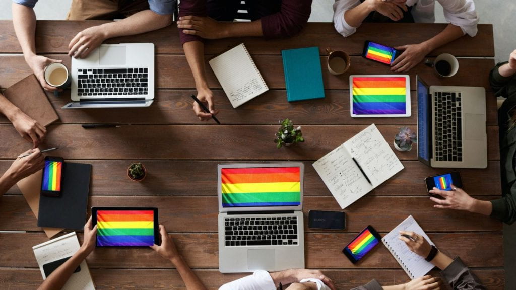 Photo of pride flags on work screens. LGBTQ Employment and Discrimination reported in the chapter, "Sexuality, Employment, and Discrimination," published in the Companion to Sexuality Studies